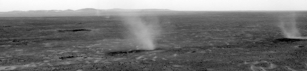 Esta imagem comos vários diabos de poeira que se deslocam de direita para a esquerda através de uma planície interior de Marte Cratera Gusev, como visto do ponto de vista da NASA Mars Exploration Rover Espírito em colinas aumento da planície.