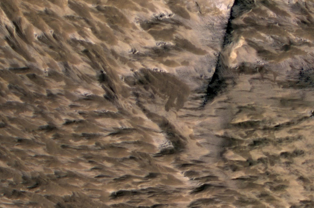 This April 6, 2014, image from the High Resolution Imaging Science Experiment (HiRISE) camera on NASA's Mars Reconnaissance Orbiter shows numerous landslides in the vicinity of where an impact crater was excavated in March 2012.
