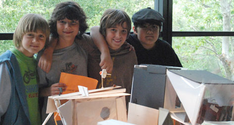 This image shows 4 boys standing behind their project.