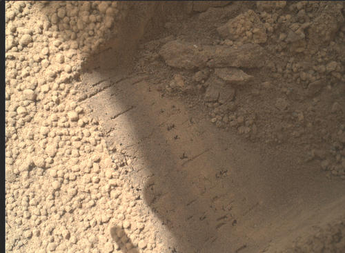 This image contributed to an interpretation by NASA's Mars rover Curiosity science team that some of the bright particles on the ground near the rover are native Martian material.