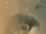 Taken in March 2002, this Surveyor image shows two inactive, ancient Mars volcanoes. The upper one is called Uranius Tholus, the lower one Ceraunius Tholus.