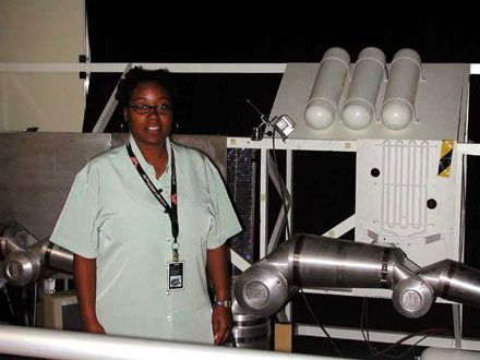 Ayanna Howard poses with a robotic arm.