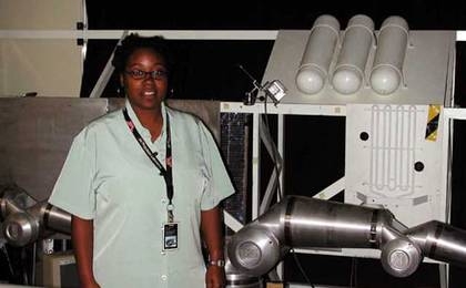 Ayanna Howard poses with a robotic arm.
