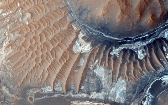 This image reveals exposed layers in Noctis Labyrinthus which may contain signatures of iron bearing sulfates and phyllosilcate (clay) minerals.