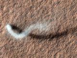 A towering dust devil casts a serpentine shadow over the Martian surface in this image acquired by the High Resolution Imaging Science Experiment (HiRISE) camera on NASA's Mars Reconnaissance Orbiter.