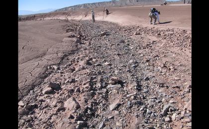 This image shows a dry streambed on an alluvial fan in the Atacama Desert, Chile, revealing the typical patchy, heterogeneous mixture of grain sizes deposited together.