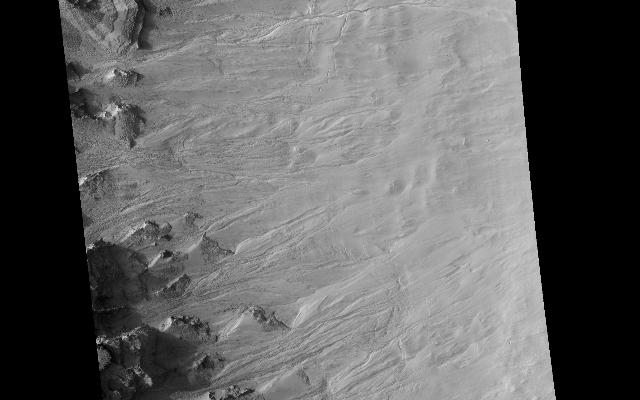 Geologically young gullies are a prime target for the HiRISE camera. Gullies are located in a variety of settings and are found all over Mars.

This "ring trough" or eroded pit crater, is located in the rugged southern highland terrain known as Noachis Terra. The HiRISE image shows the layered, boulder-rich wall rock facing to the northeast and gullies that are transporting material downslope.

The material collects into debris aprons along the walls, which often exhibit narrow channels along its surface.