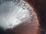 This image shows frost on a crater slope.  The white frost covers nearly the top side of the crater, while the bottom part appears reddish in color.
