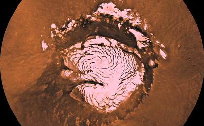 Mars digital-image mosaic merged with color of the MC-1 quadrangle, Mare Boreum region of Mars. The central part is covered by a residual ice cap that is cut by spiral-patterned troughs exposing layered terrain. The cap is surrounded by broad flat plains and large dune fields.