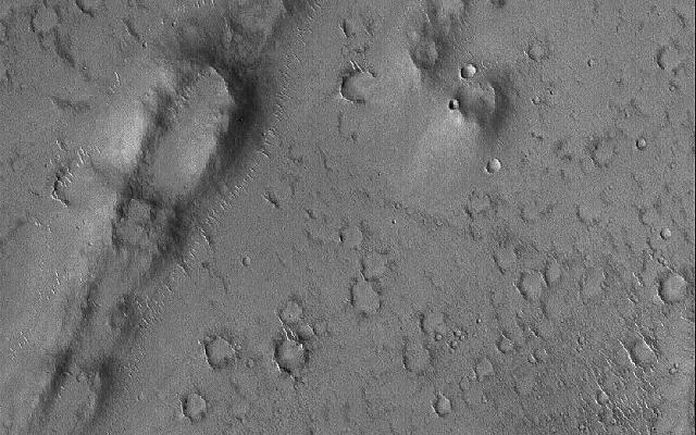 This Mars Global Surveyor (MGS) Mars Orbiter Camera (MOC) image shows a curved, pitted ridge in Isidis Planitia. This feature may be a remnant of a once more-extensive layer of material that covered the present, cratered surface.