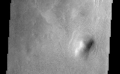 This THEMIS image of rounded hills and ridges in Arcadia Planitia shows a very intriguing geomorphic feature that may be attributed to the presence of an icy-rock mixture of material. Smooth aprons of material are observed to be preferentially located on the cold, north facing slopes of hills and extend further and beyond the deposits located on other sides. These smooth deposits are in stark contrast to the more rough surfaces that dominate the scene and it has been suggested that they represent a preserved mixture of ice and rock. How exactly this deposit forms still remains a mystery. They may have been "pasted" onto the slopes and preserved on the cold facing sides or they may represent the result of downslope motion of material that is enhanced by the presence of ground ice. In either case, this interesting observation suggests that ground ice may still play an important role in the formation and preservation of martian surface features.