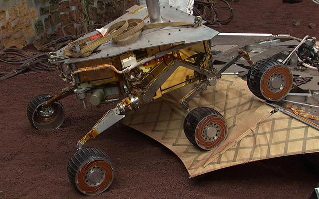 This still image illustrates what the Mars Exploration Rover Spirit will look like as it rolls off the northeastern side of the lander on Mars. The image was taken from footage of rover testing at JPL's In-Situ Instruments Laboratory, or "Testbed."