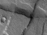This Mars Global Surveyor (MGS) Mars Orbiter Camera (MOC) image shows cross-cutting fault scarps among graben features in northern Tempe Terra. Graben form in regions where the crust of the planet has been extended; such features are common in the regions surrounding the vast "Tharsis Bulge" on Mars.