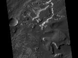 This HiRISE image covers the southwest portion of the terraces and floor of Holden Crater situated in southwest Margaritifer Terra. The HiRISE sub-frame shows the most clearly-evident image of a megabreccia on Mars. Breccia is a rock typically consisting of rock fragments of various sizes and shapes that have been broken, tumbled and cemented together in sudden geologic event (e.g., a landslide, a flashflood or even an impact-cratering event). If it were not for the dark sandy dunes dispersed through out the sub-image, this image could easily fool an expert into thinking that this image is actually a photograph of a hand sample of an impact breccia. The prefix "mega" implies that the breccia in the sub-image consists of clasts, or rock fragments, that are typically larger than a large house or a building. The rectangular megaclast near the center of the image is a colossal 50 x 25 meters (~150 X 75 feet). As mentioned in the transition image caption for Holden crater (TRA_000861_1530), the crater likely experienced extensive modification by running water, which is supported by observations of drainage and deposition into the crater from a large channel (Uzboi Valles) breaching Holden's southwest rim. While it is possible that the megabreccia formed from a catastrophic release of water into the crater, a more likely possibility is that it formed from the impact that created the approx. 150 km-in-diameter Holden crater. Popigai Crater, a terrestrial crater of half the size of Holden, possesses a similar occurrence of megabreccia with a similar range in megaclast size to the Holden crater example. An impact-generated megabreccia deposit, as observed in terrestrial craters, typically lies beneath the crater floor, so the exhumation of the megabreccia may be the result of down-cutting and erosion of water that once flowed through Uzboi Valles.