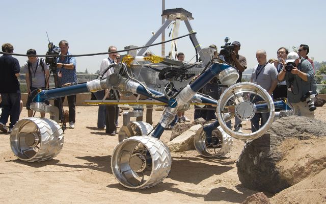 Onlookers watch as Scarecrow, a mobility-testing model for NASA's Mars Science Laboratory, easily conquers boulders in the Mars Yard testing area at NASA's Jet Propulsion Laboratory.
