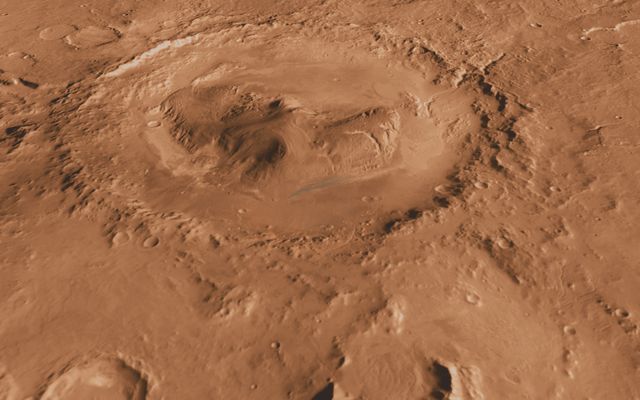 This oblique, southward-looking view of Gale crater shows the mound of layered rocks that NASA's Mars Science Laboratory will investigate. The mission's selected landing site is just north of the mound inside the crater.