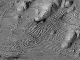 Rhythmic patterns of sedimentary layering in Danielson Crater on Mars result from periodic changes in climate related to changes in tilt of the planet.