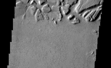 Echus Chasma forms the boundary between the Tharsis volcanoes to the west and Lunae Planum to the east. This region is one of both tectonically fractured rocks (top of image) and volcanic flows (middle and bottom of image). Echus Chasma empties into Kasei Valles.