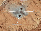 This image shows the first holes into rock drilled by NASA's Mars rover Curiosity, with drill tailings around the holes plus piles of powdered rock collected from the deeper hole and later discarded after other portions of the sample had been delivered to analytical instruments inside the rover.