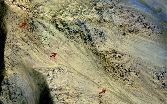 This image includes an especially long example of a type of dark marking that advances down some Martian slopes in warmer months and fades away in cooler months.