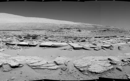 A landscape scene from NASA's Curiosity Mars rover shows rock rows at "Junda" forming striations in the foreground, with Mount Sharp on the horizon. The component images were taken by the rover's Navigation Camera (Navcam), looking southward, during a pause in driving on Feb. 19.