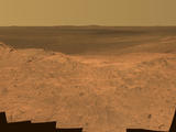 This scene from the panoramic camera (Pancam) on NASA's Mars Exploration Rover Opportunity catches "Pillinger Point," on the western rim of Endeavour Crater, in the foreground. The eastern rim of the crater is on the distant horizon. The scene merges many Pancam exposures taken on May 14, 2014.
