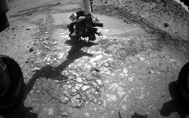 This image from the front Hazcam on NASA's Curiosity Mars rover shows the rover's drill in place during a test of whether the rock beneath it, 'Bonanza King,' would be an acceptable target for drilling to collect a sample.