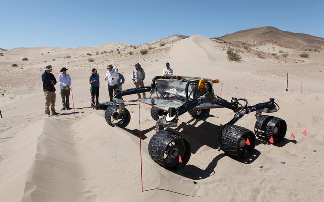 sand dune, mars rover, wheel, Dumont, Scarecrow, test - Several engineers watch as the Scarecrow test rover goes over a dunes obstacle course.