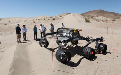 sand dune, mars rover, wheel, Dumont, Scarecrow, test - Several engineers watch as the Scarecrow test rover goes over a dunes obstacle course.