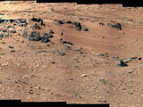 This patch of windblown sand and dust downhill from a cluster of dark rocks is the "Rocknest" site, which has been selected as the likely location for first use of the scoop on the arm of NASA's Mars rover Curiosity.