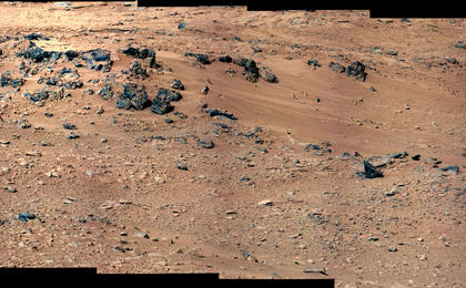 This patch of windblown sand and dust downhill from a cluster of dark rocks is the "Rocknest" site, which has been selected as the likely location for first use of the scoop on the arm of NASA's Mars rover Curiosity.
