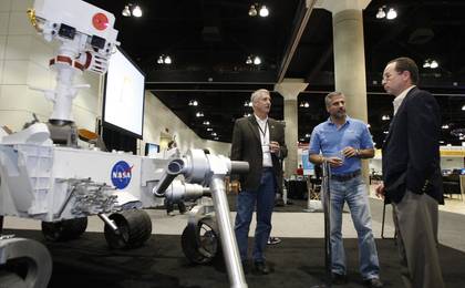 Doug McCuistion, Walid Abu-Hadba, and Roger Gibbs in the 'Big Room' at Microsoft's Professional Developers Conference, with a full-scale model of the Mars rover 'Curiosity,'scheduled to launch in 2011.
