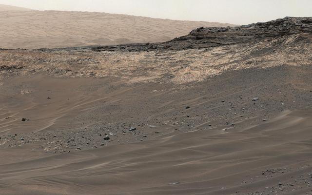 This May 10, 2015, view from Curiosity's Mastcam shows terrain judged difficult for traversing between the rover and an outcrop in the middle distance where a pale rock unit meets a darker rock unit above it. The rover team decided not to approach this outcrop and identified an alternative.