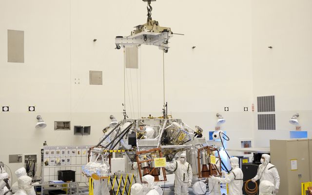 Technicians, at the Payload Hazardous Servicing Facility at NASA's Kennedy Space Center in Florida, use an overhead crane to move a rocket-powered descent stage for integration with NASA's Mars Science Laboratory (MSL) rover, known as Curiosity.