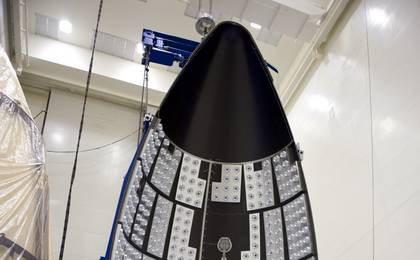 In the Payload Hazardous Servicing Facility at NASA's Kennedy Space Center in Florida, a section of the Atlas V payload fairing for NASA's Mars Science Laboratory (MSL) mission hangs vertically from the ceiling.