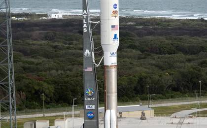 On Cape Canaveral Air Force Station in Florida, the 197-foot-tall United Launch Alliance Atlas V rocket arrives on the launch pad at Space Launch Complex-41, situated near the Atlantic Ocean.