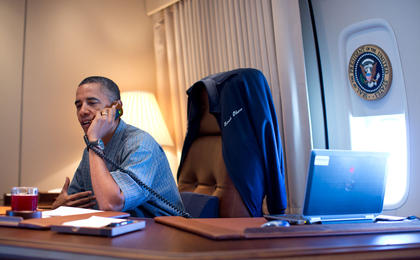 President Barack Obama talks on the phone with NASA's Curiosity Mars rover team aboard Air Force One during a flight to Offutt Air Force Base in Nebraska, Aug. 13, 2012.