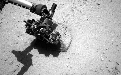 This image shows the robotic arm of NASA's Mars rover Curiosity with the first rock touched by an instrument on the arm.