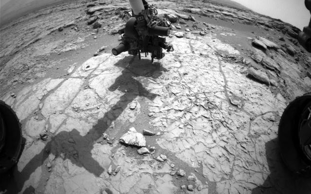 The percussion drill in the turret of tools at the end of the robotic arm of NASA's Mars rover Curiosity has been positioned in contact with the rock surface in this image from the rover's front Hazard-Avoidance Camera (Hazcam).