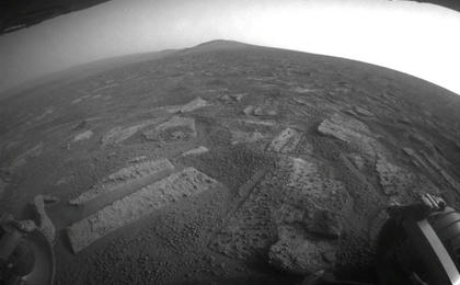 This view shows the terrain that NASA's Mars Exploration Rover Opportunity is crossing in a flat area called "Botany Bay" on the way toward "Solander Point," which is visible on the horizon.