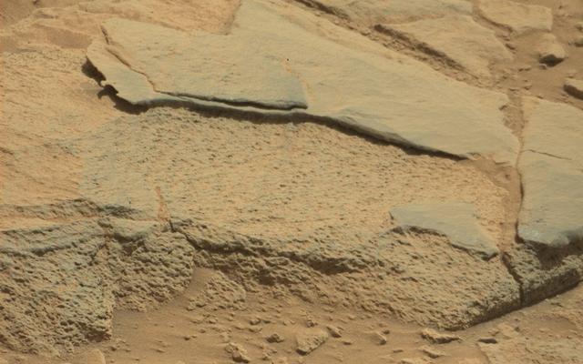 The rock "Ithaca" shown here, with a rougher lower texture and smoother texture on top, appears to be a piece of the local sedimentary bedrock protruding from the surrounding soil in Gale Crater.