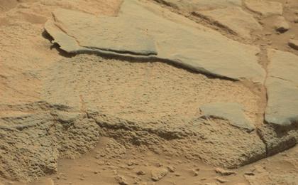 The rock "Ithaca" shown here, with a rougher lower texture and smoother texture on top, appears to be a piece of the local sedimentary bedrock protruding from the surrounding soil in Gale Crater.