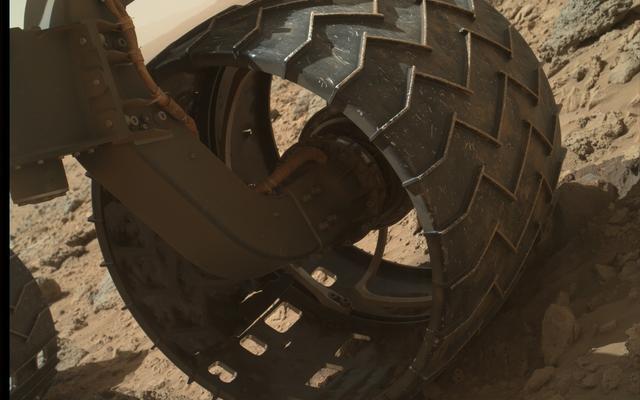 The left-front wheel of NASA's Curiosity Mars rover shows dents and holes in this image taken during the 469th Martian day, or sol, of the rover's work on Mars (Nov. 30, 2013).