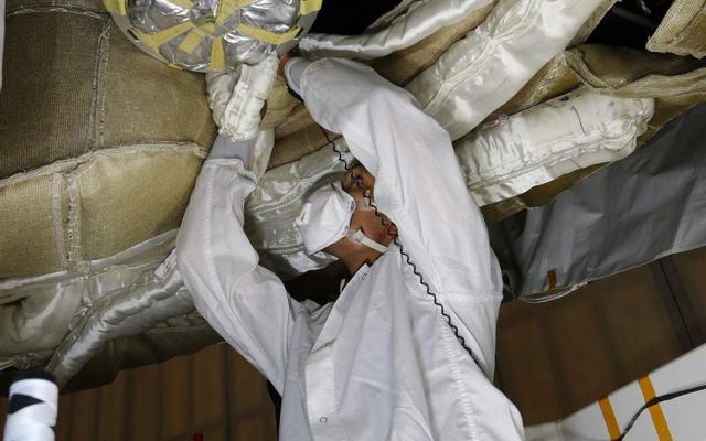 An engineer works on the Parachute Deployment Device of the Low Density Supersonic Decelerator test vehicle in this image taken at the Missile Assembly Building at the US Navy's Pacific Missile Range Facility in Kaua'i, Hawaii.