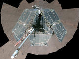 A self-portrait from overhead shows a view of the rover solar panels, which appear grayish-green and wiped clean of dust.
