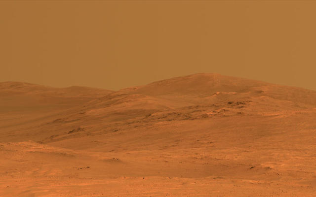 This vista of the Endeavour Crater rim was acquired by NASA's Mars Exploration Rover Opportunity's panoramic camera on April 18, 2014, from the southern end of "Murray Ridge" on the western rim of the crater. In mid-May, the rover approached the dark outcrops on the flank of the hill at right.