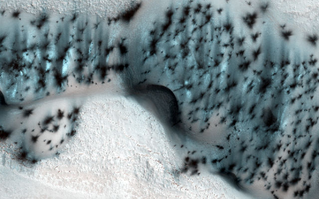 These barchan (crescent-shaped) sand dunes are found within the North Polar erg of Mars.