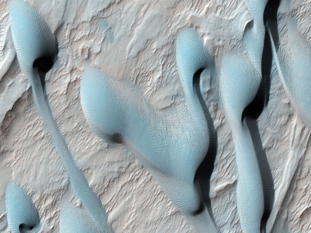 This scene shows dark sand dunes marching over the ridges created by an alluvial (water-deposited) fan in an impact crater.