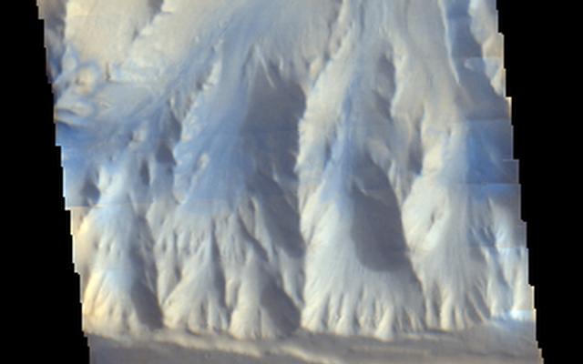 Morning clouds fill Coprates Chasma on Mars in this Nov. 25, 2015, image from the THEMIS camera on NASA's Mars Odyssey. No orbiter systematically observed Mars in morning sunlight before 2015. The clouds appear blue because ice particles in them scatter blue light more strongly than other colors.