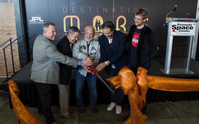A ceremonial ribbon is cut for the opening of new "Destination: Mars" experience at the Kennedy Space Center visitor complex in Florida. From the left are Therrin Protze, chief operating officer of the visitor complex; center director Bob Cabana; Apollo 11 astronaut Buzz Aldrin; Kudo Tsunoda of Microsoft; and Jeff Norris of NASA's Jet Propulsion Laboratory in Pasadena, California.